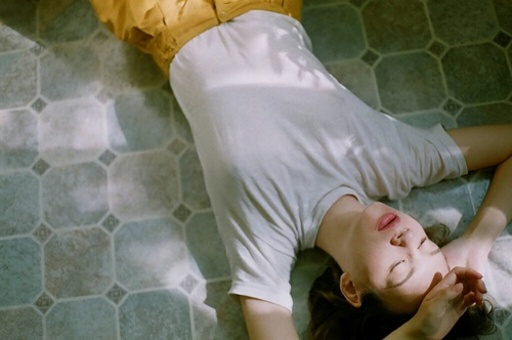 床に寝転ぶ女性