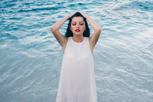 海辺で見上げる女性の写真