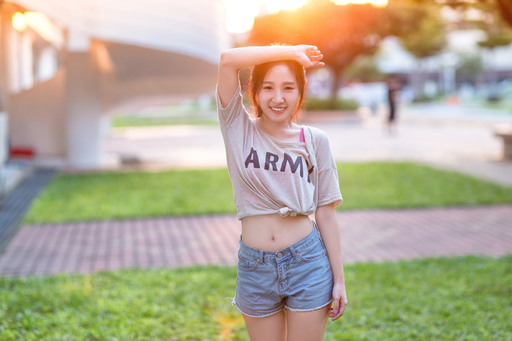 おへそを出して笑う女性の写真