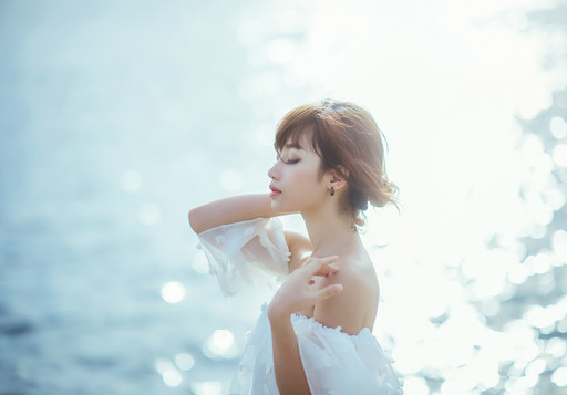 海の風を感じている女性の写真