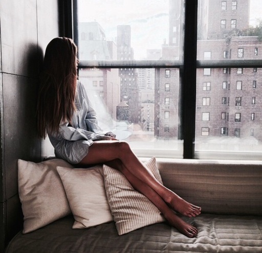 窓の外を眺める女性の写真