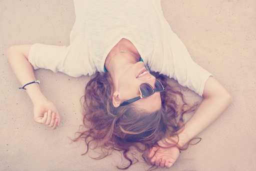 サングラスをして笑う女性の写真