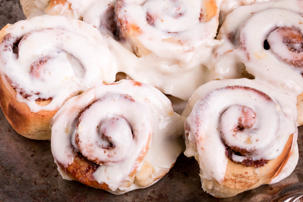 Soft, Moist and Fresh Homemade Cinnamon Buns. Cinnamon Rolls with Cream Cheese Icing for Breakfast.