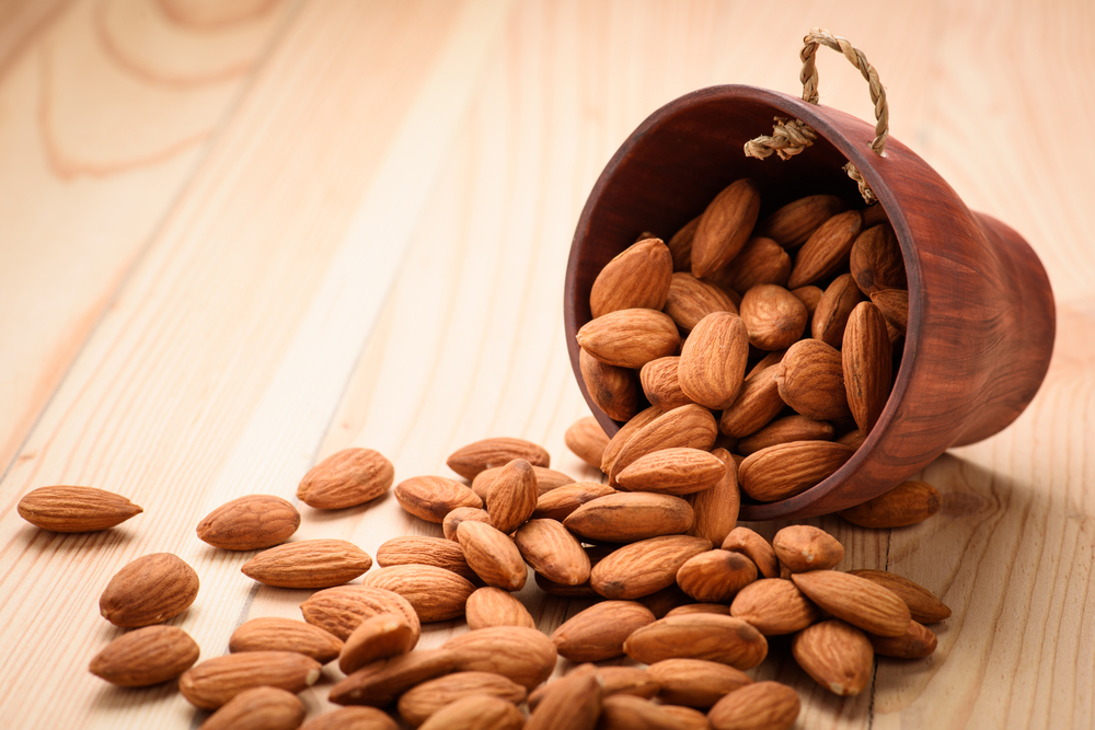 Almonds pour from wood Cup