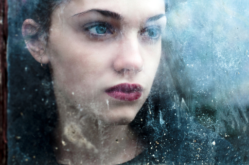 窓の外をみる女性の写真