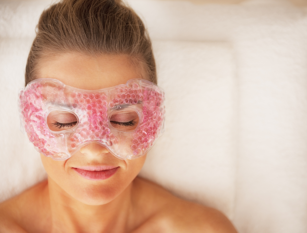 Portrait of young woman in eye mask laying on massage table