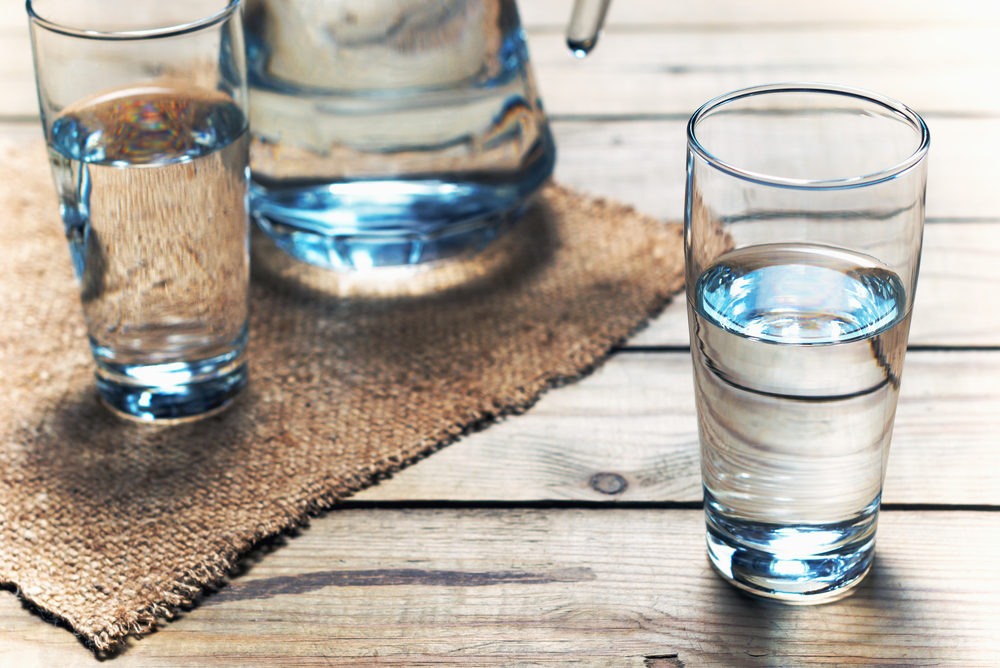 Glasses of water on a wooden table. Selective focus. Shallow DOF