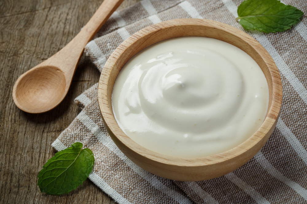 Homemade yogurt or sour cream in a wooden bowl