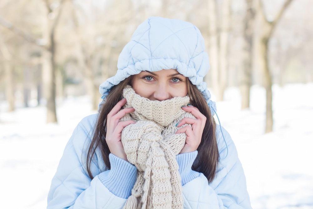 Winter Portrait of Young Woman wearing clothing for cold weather at snow day. Happy Caucasian female wintertime season outdoor.