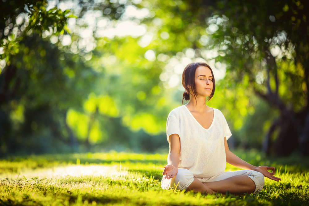 Young girl doing yoga in the park