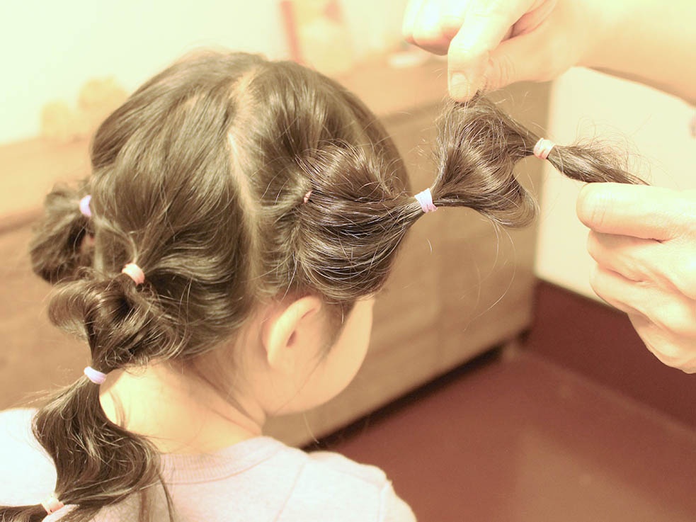 ②2~3cmほど間隔を空けてゴムで結び、髪を引き出して玉ねぎのような丸い形をつくっていきます。